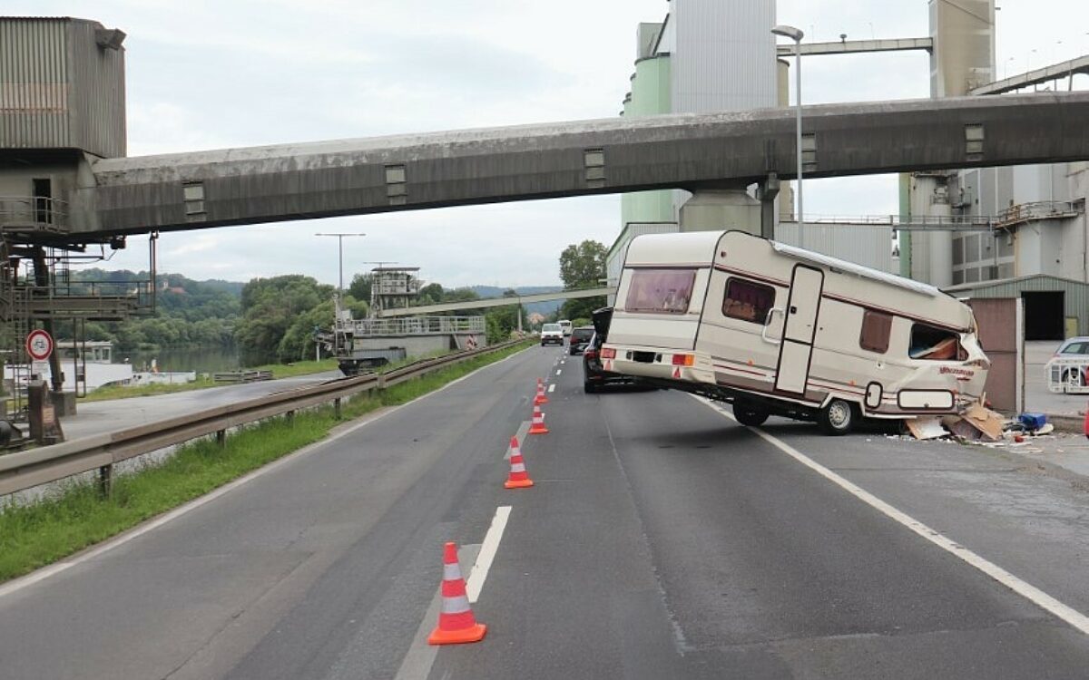 Ein völlig zerstörter Wohnwagen hängt nach einem Unfall an einer Mauer Ein völlig zerstörter Wohnwagen hängt nach einem Unfall an einer Mauer
